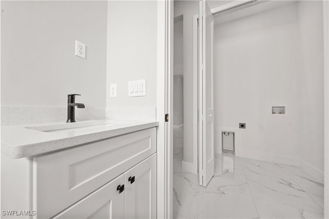 bathroom with marble finish floor, baseboards, and vanity