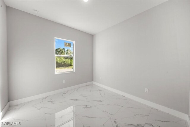 1034 Green Field St, Lehigh Acres, FL 33974 - empty room with light marble finish flooring, baseboards, and a smoke detector