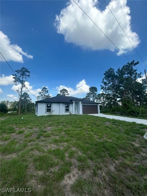 1034 Green Field St, Lehigh Acres, FL 33974 - view of front facade with an attached garage, stucco siding, driveway, and a front lawn