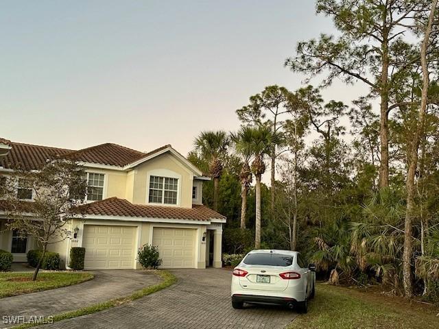 1280 Henley St Unit 1601, Naples, FL 34105 - view of front of property featuring a garage, stucco siding, driveway, and a tile roof