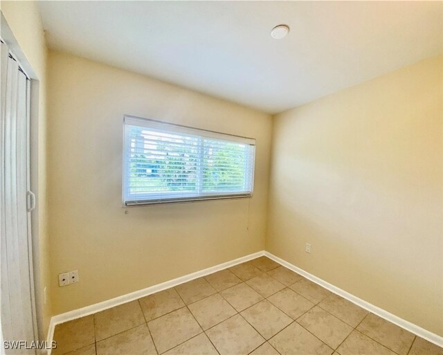 spare room featuring baseboards and light tile patterned floors