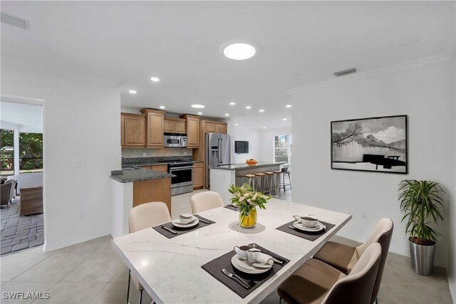 750 Southern Pines Dr, Naples, FL 34103 - dining space with light tile patterned floors, recessed lighting, ornamental molding, and baseboards