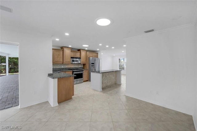 750 Southern Pines Dr, Naples, FL 34103 - kitchen featuring appliances with stainless steel finishes, plenty of natural light, light tile patterned flooring, brown cabinets, and recessed lighting
