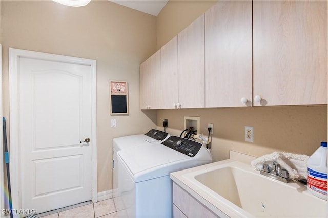 washroom featuring cabinet space, light tile patterned flooring, a sink, separate washer and dryer, and baseboards