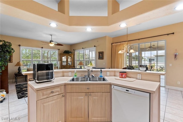 kitchen featuring light brown cabinetry, light tile patterned flooring, a sink, and dishwasher