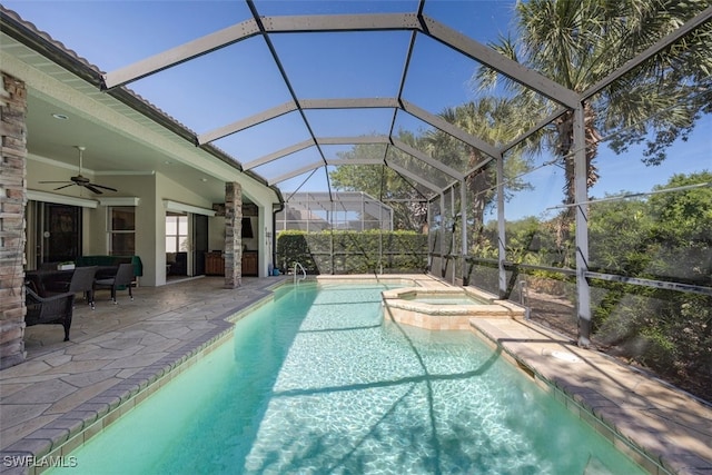 outdoor pool with glass enclosure, an in ground hot tub, a patio area, and ceiling fan