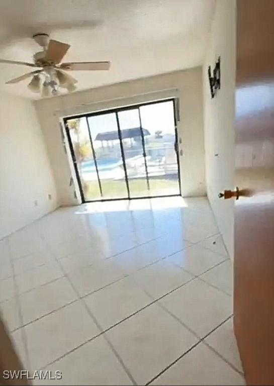 unfurnished room featuring ceiling fan and tile patterned flooring