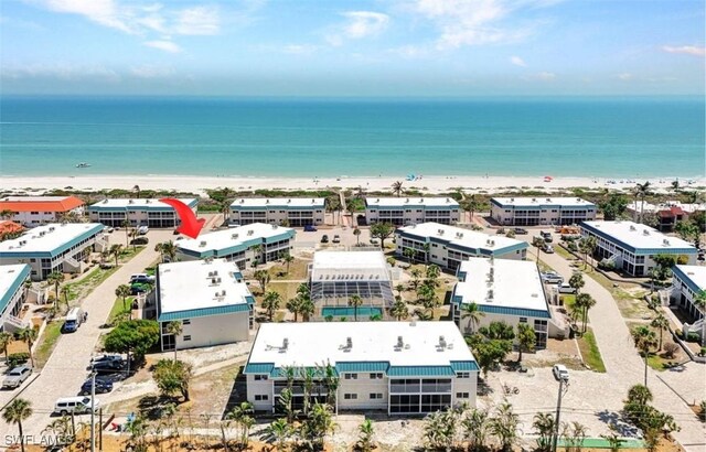 drone / aerial view with a water view and a beach view