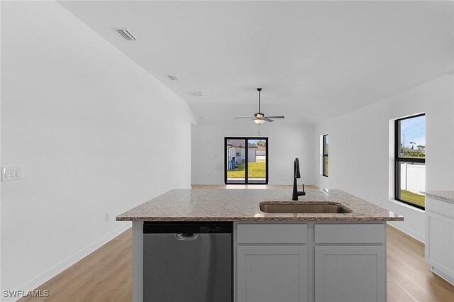 1621 NW 7th Ter, Cape Coral, FL 33993 - kitchen with stainless steel dishwasher, a sink, light wood-type flooring, light stone countertops, and a ceiling fan