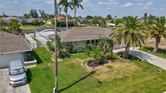 423 SE 17th St, Cape Coral, FL 33990 - view of front facade featuring fence, a residential view, driveway, and a front yard