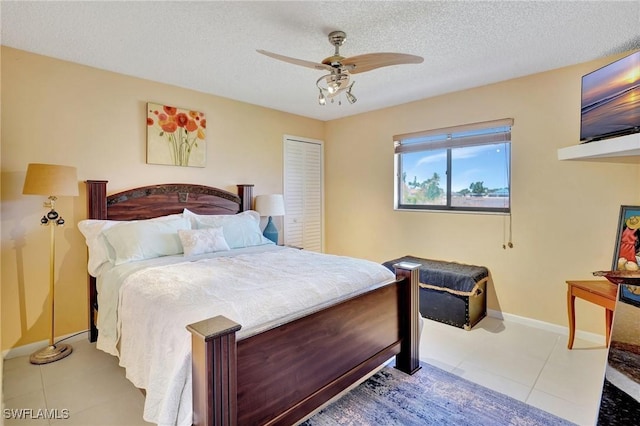 423 SE 17th St, Cape Coral, FL 33990 - tiled bedroom with a textured ceiling, a ceiling fan, a closet, and baseboards