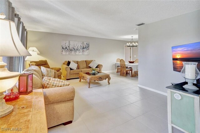 423 SE 17th St, Cape Coral, FL 33990 - living area with a notable chandelier, visible vents, a textured ceiling, baseboards, and tile patterned flooring
