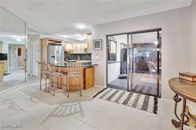 423 SE 17th St, Cape Coral, FL 33990 - kitchen featuring tasteful backsplash, a ceiling fan, dark countertops, and stainless steel fridge with ice dispenser