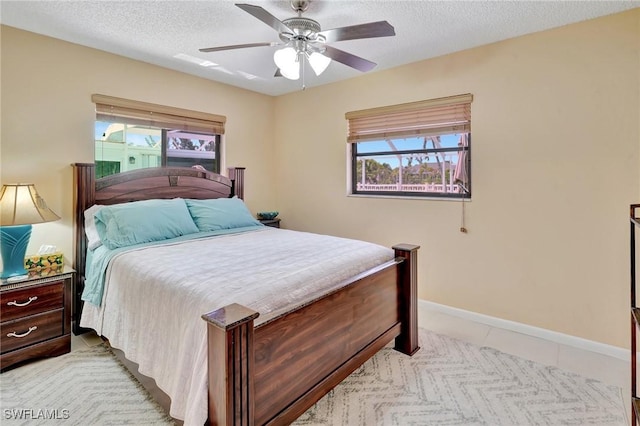 423 SE 17th St, Cape Coral, FL 33990 - bedroom with a textured ceiling, a ceiling fan, baseboards, and multiple windows