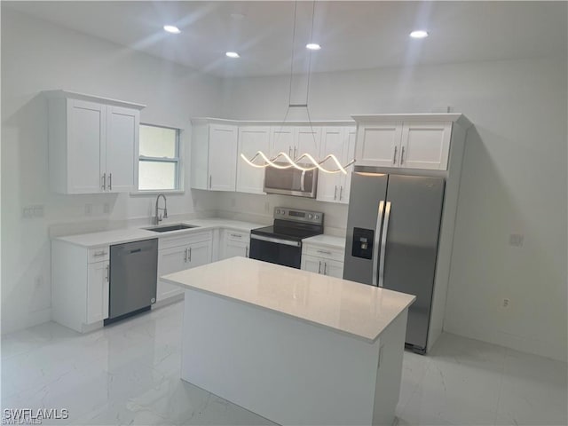 kitchen featuring white cabinetry, marble finish floor, a sink, and stainless steel appliances