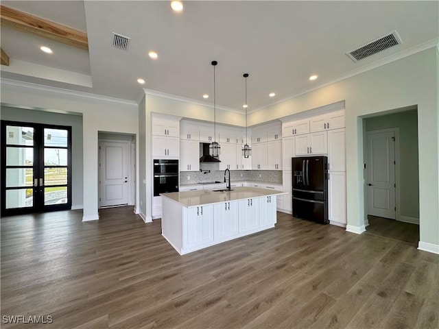 kitchen with white cabinetry, wall chimney range hood, black appliances, and visible vents