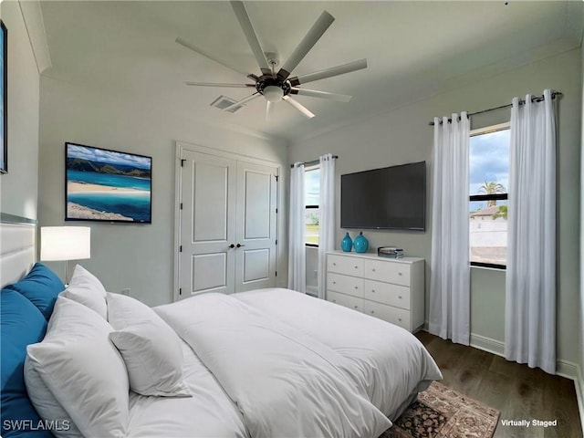 bedroom with dark wood-type flooring, visible vents, multiple windows, and baseboards