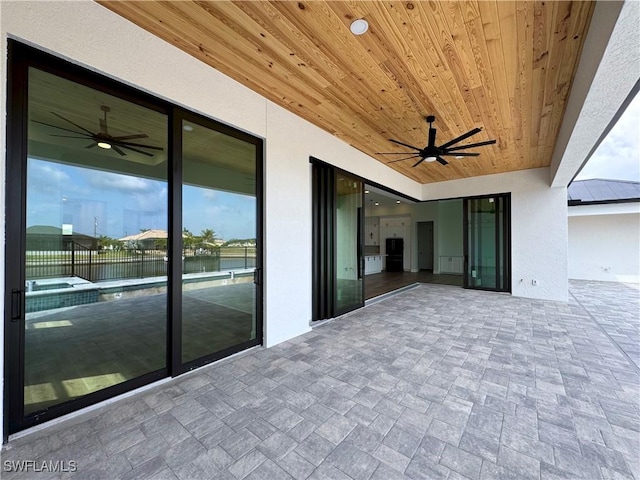 view of patio featuring a ceiling fan and a water view