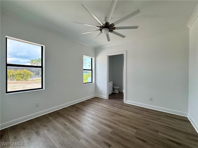 unfurnished bedroom with crown molding, baseboards, and dark wood finished floors