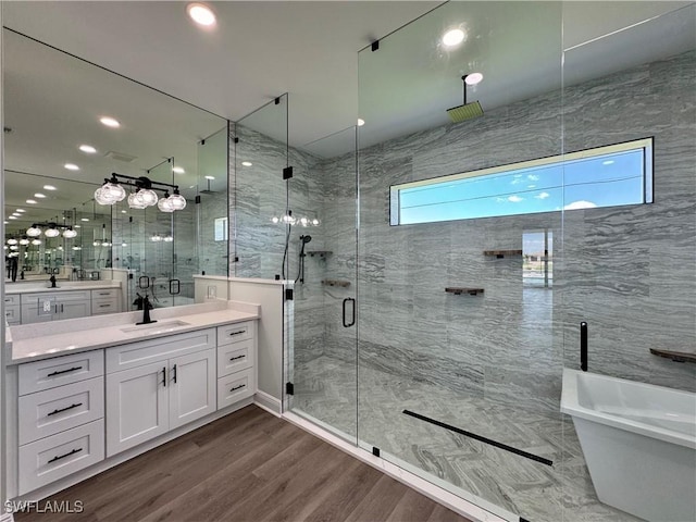 full bathroom with a soaking tub, a shower stall, vanity, recessed lighting, and wood finished floors