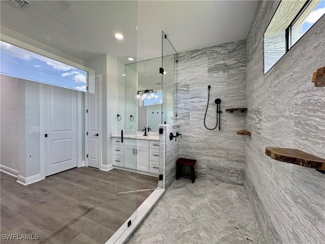 full bathroom with vanity, recessed lighting, a walk in shower, a wood stove, and visible vents
