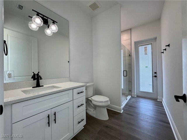 full bath featuring visible vents, toilet, a shower stall, vanity, and wood finished floors