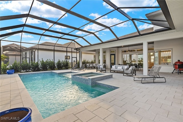 view of pool featuring a ceiling fan, a pool with connected hot tub, a patio area, an outdoor living space, and glass enclosure