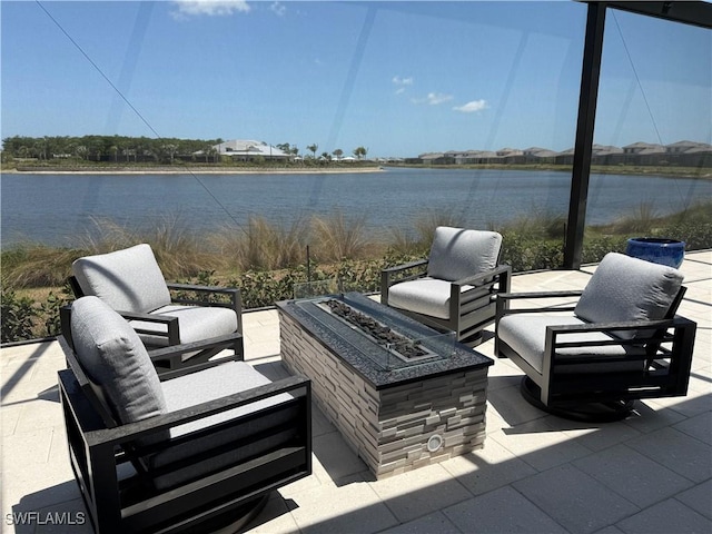 view of patio with an outdoor fire pit and a water view