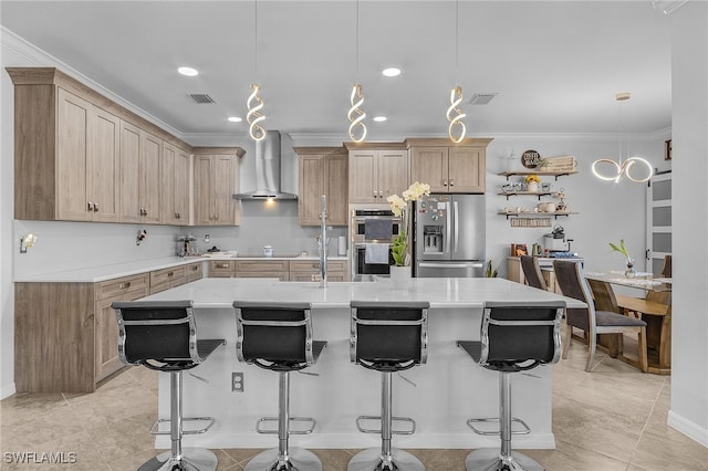 kitchen with a breakfast bar area, appliances with stainless steel finishes, crown molding, and wall chimney exhaust hood