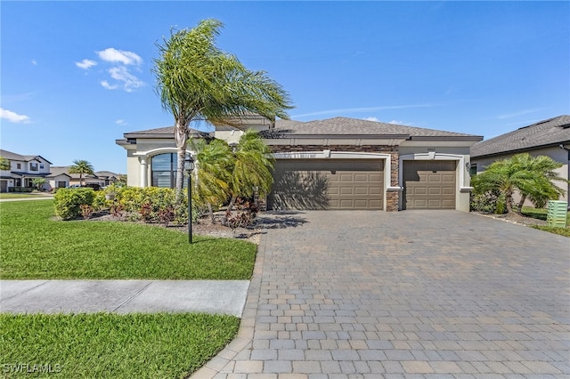 view of front of house with stone siding, stucco siding, an attached garage, a front lawn, and decorative driveway