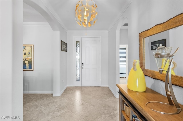 entryway featuring arched walkways, crown molding, and a chandelier