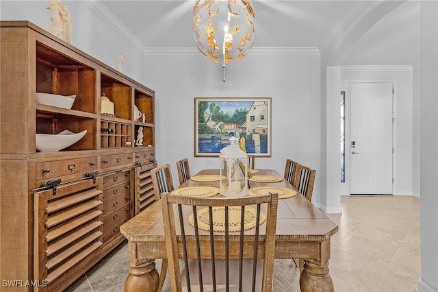 dining area with baseboards, ornamental molding, arched walkways, and a notable chandelier