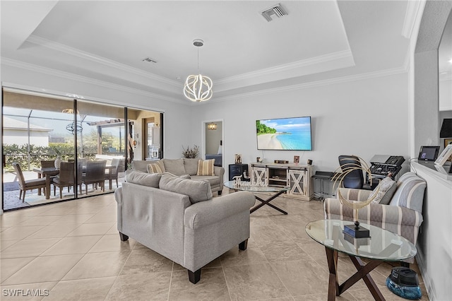 living area featuring an inviting chandelier, a tray ceiling, and visible vents