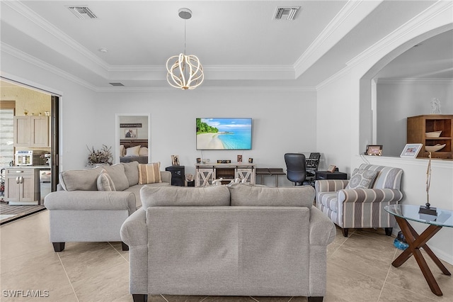 living area with visible vents, a notable chandelier, arched walkways, and a raised ceiling