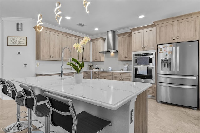 kitchen featuring crown molding, wall chimney exhaust hood, light brown cabinetry, and stainless steel appliances