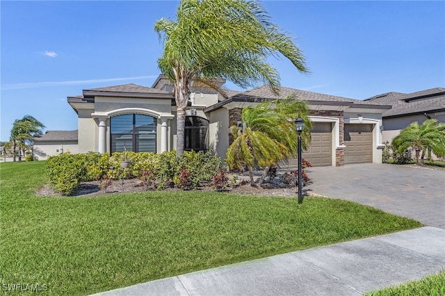 view of front of home with stucco siding, decorative driveway, a front lawn, and an attached garage