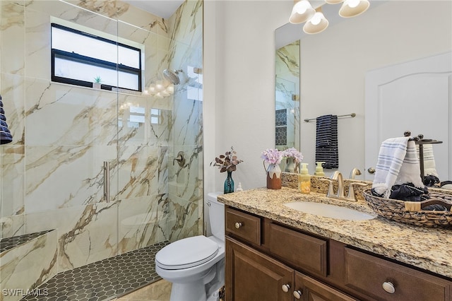 bathroom featuring a marble finish shower, toilet, and vanity