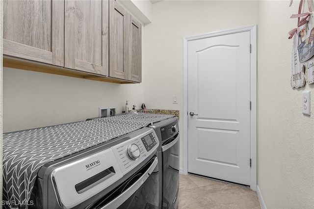 laundry room with washer and clothes dryer, cabinet space, and baseboards