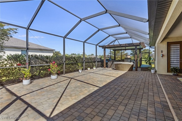 view of patio / terrace with a lanai and a hot tub