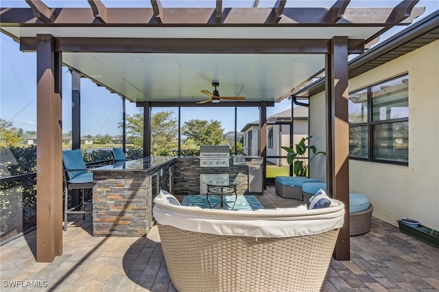view of patio / terrace featuring exterior kitchen, an outdoor living space, ceiling fan, area for grilling, and a pergola