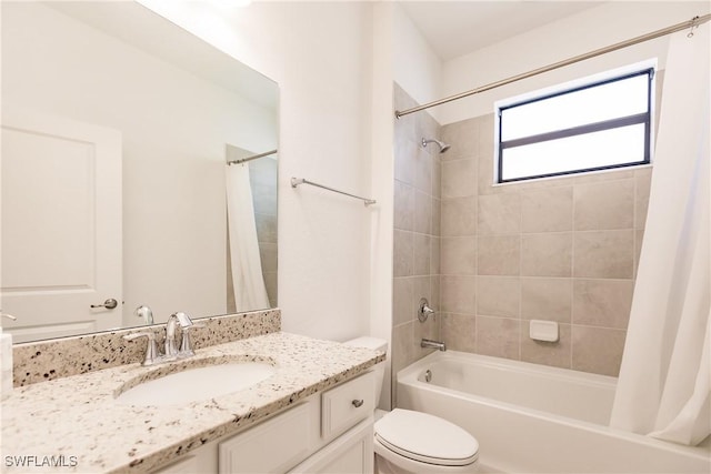 bathroom featuring toilet, shower / bath combo with shower curtain, and vanity
