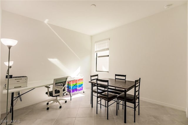 tiled dining area featuring baseboards