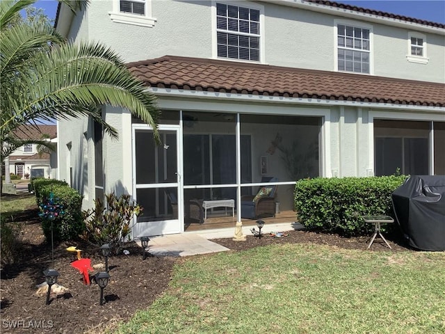 11739 Eros Rd, Lehigh Acres, FL 33971 - rear view of house featuring a tile roof, a sunroom, and stucco siding