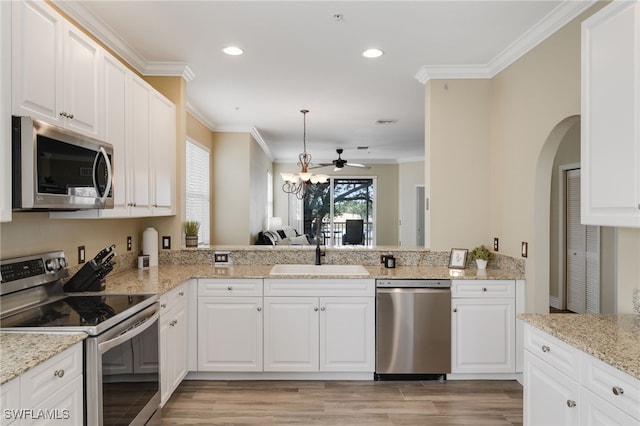 11991 Champions Green Way Unit 608, Fort Myers, FL 33913 - kitchen featuring stainless steel appliances, a sink, ornamental molding, light wood-style flooring, and arched walkways