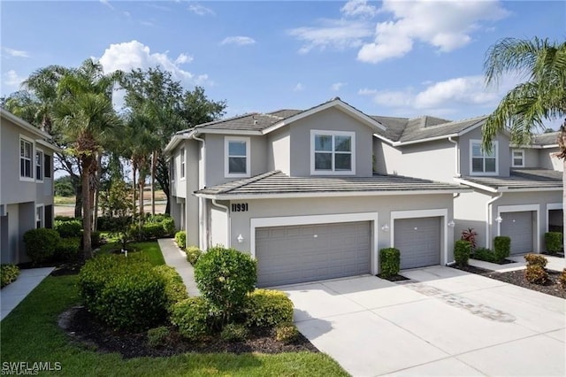 11991 Champions Green Way Unit 608, Fort Myers, FL 33913 - view of front of property featuring a garage, stucco siding, concrete driveway, and a tile roof