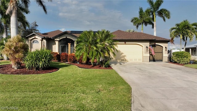 24342 Saragossa Ln, Punta Gorda, FL 33955 - view of front of property with stucco siding, an attached garage, driveway, a front lawn, and roof mounted solar panels