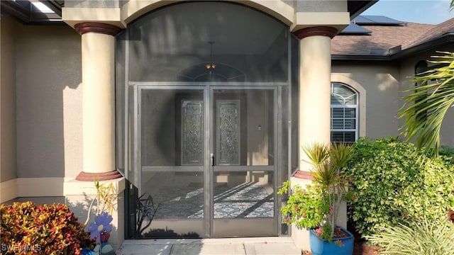 24342 Saragossa Ln, Punta Gorda, FL 33955 - view of exterior entry with stucco siding and solar panels