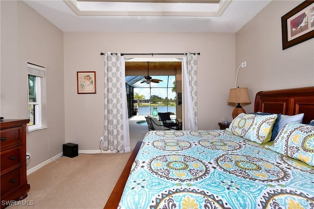 24342 Saragossa Ln, Punta Gorda, FL 33955 - carpeted bedroom featuring a tray ceiling, access to exterior, and baseboards
