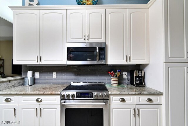 24342 Saragossa Ln, Punta Gorda, FL 33955 - kitchen featuring white cabinets, decorative backsplash, and appliances with stainless steel finishes
