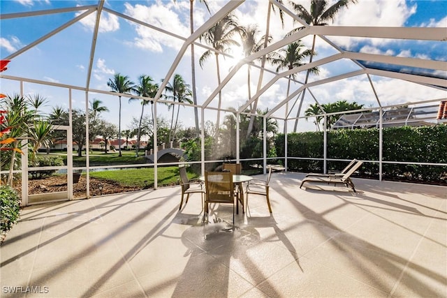 view of patio featuring outdoor dining area and glass enclosure
